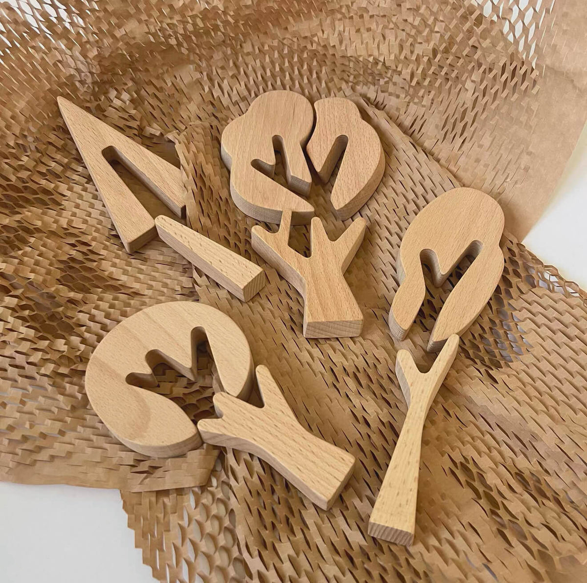 Unfinished wooden tree shapes arranged on a woven mat for DIY crafts
