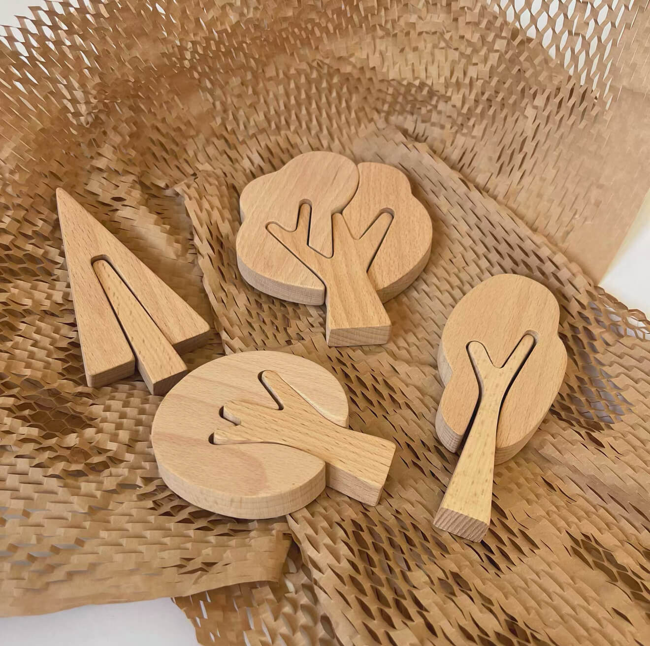 Unfinished wooden tree cutouts arranged on a woven mat