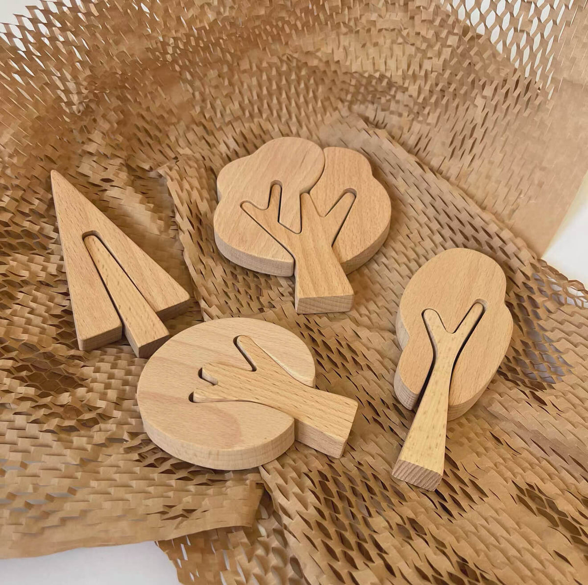 Unfinished wooden tree cutouts displayed on a natural woven mat