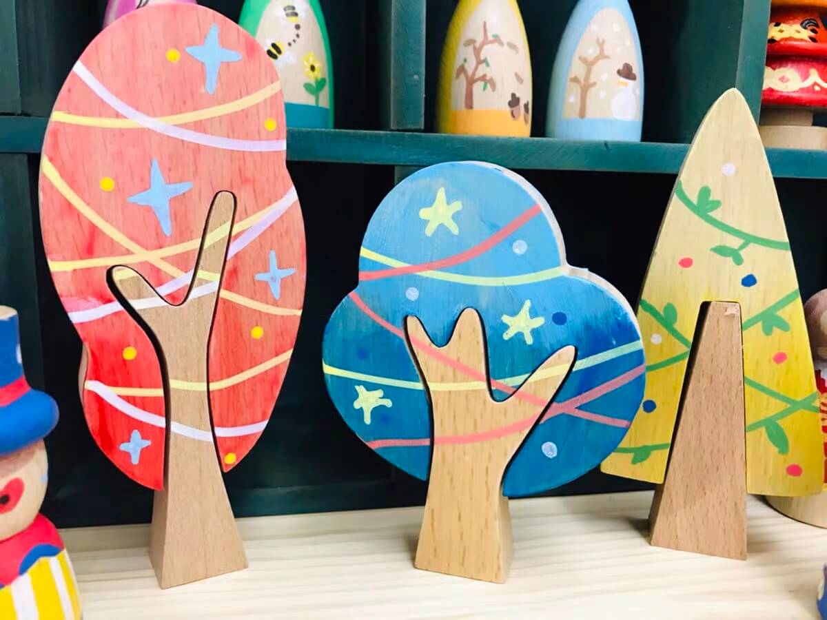 Three colorful customer painted wooden trees displayed together