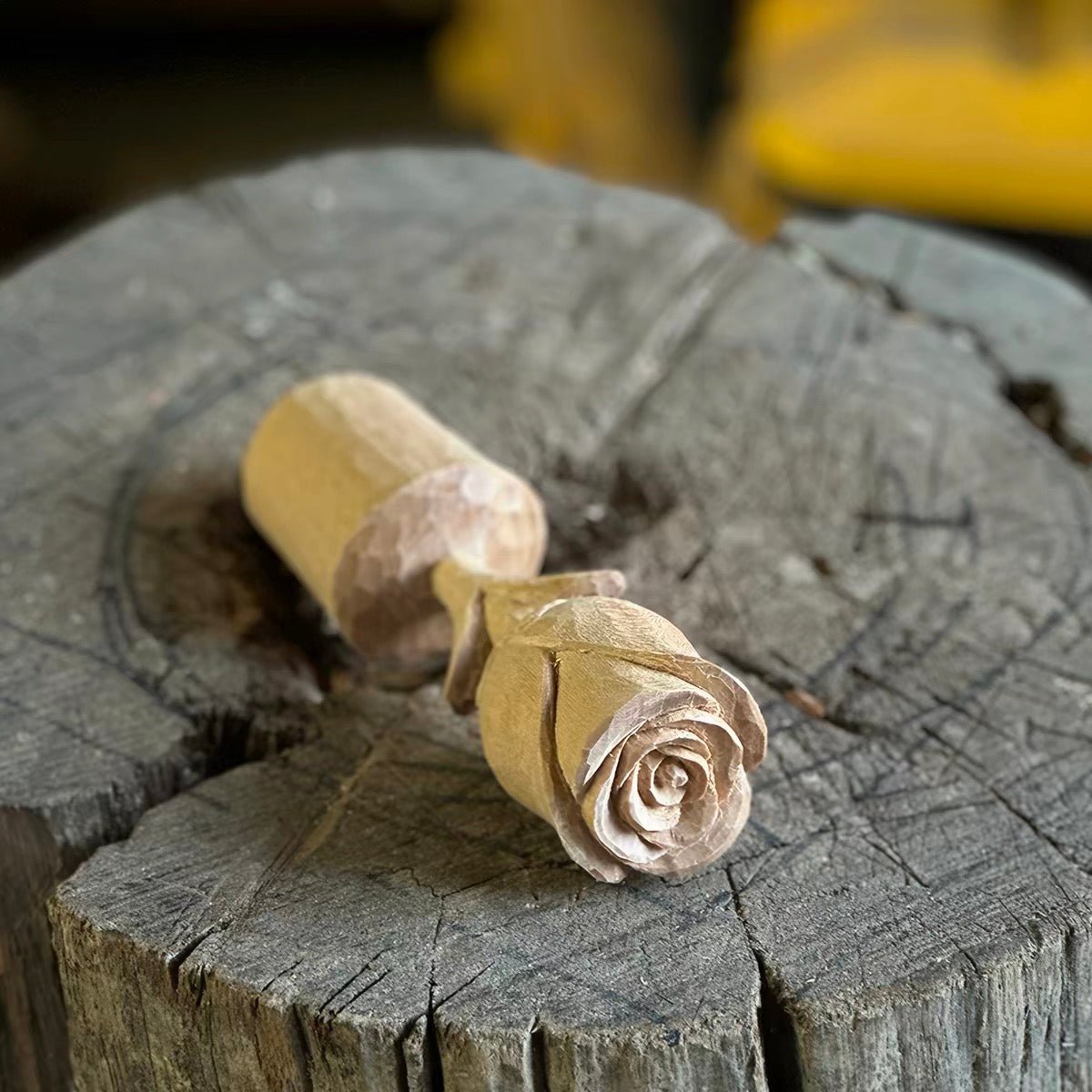Finished hand-carved wooden rose displayed on a wooden surface