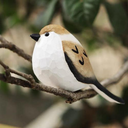 A wooden Painted Sparrow perches on a tree branch