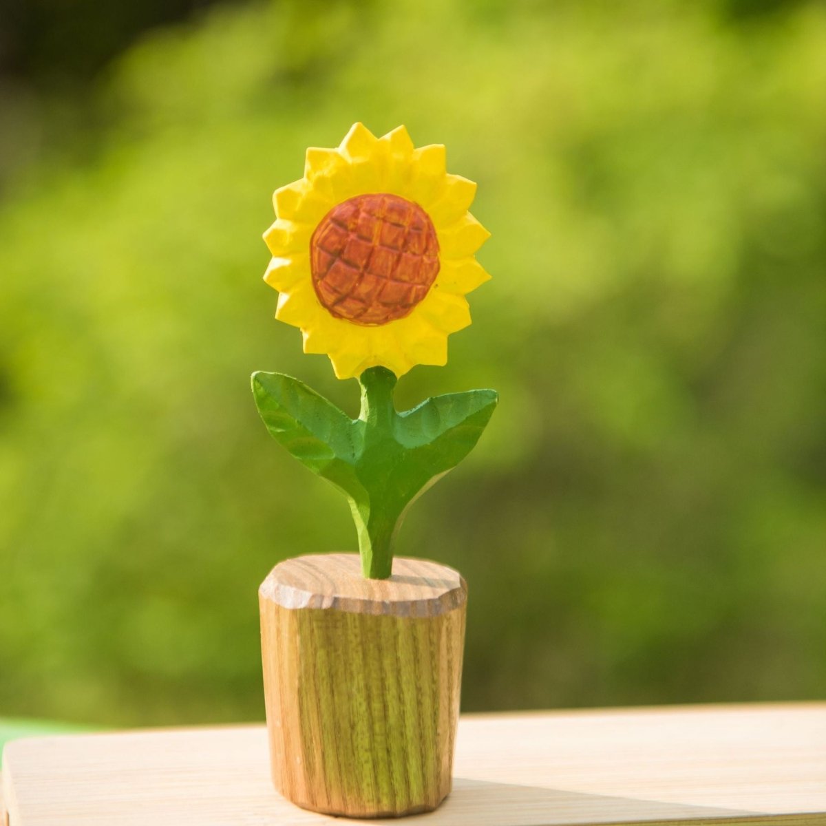 Finished DIY wooden sunflower painted yellow and green, displayed outdoors