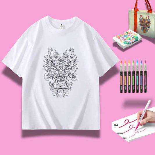 A white t-shirt featuring a detailed doodle of a proud dargon, surrounded by art supplies including markers and watercolor paints.
