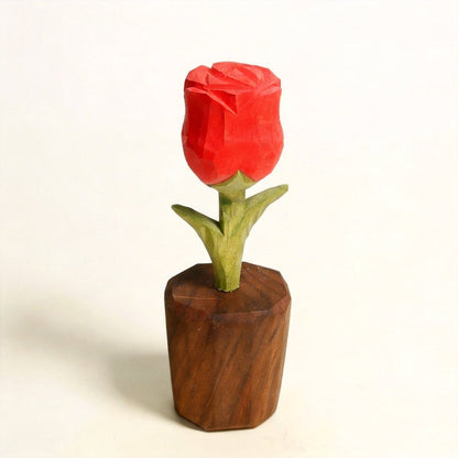 A beautifully carved wooden flower arrangement featuring a red rose in a wooden vase.