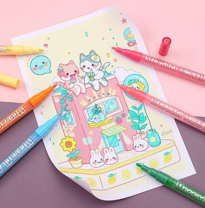 Colorful hard-tip acrylic markers beside a decorated wooden coaster and a white mug on a pastel background.