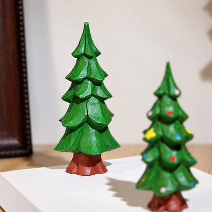Close-up of a carved green wooden Christmas tree showing hand-painted texture and details