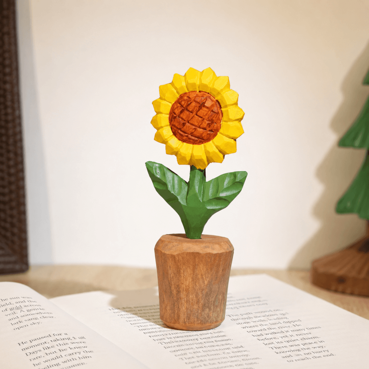 Close-up of a hand-carved wooden sunflower displayed in a small wooden pot