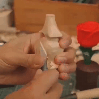 A person carving a wooden product, showcasing intricate details.