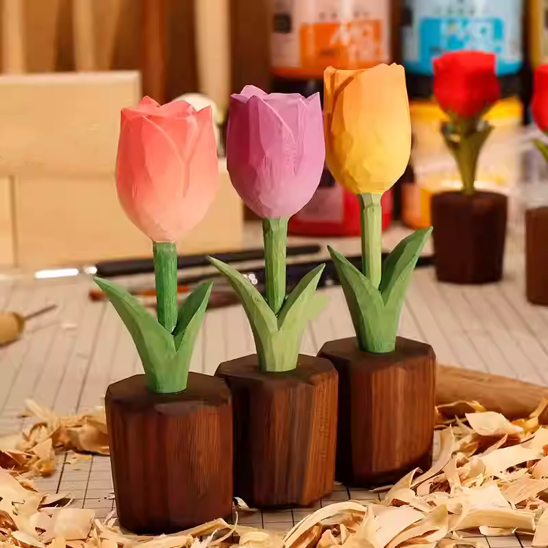 Three colorful wooden tulips in decorative pots on a crafting table