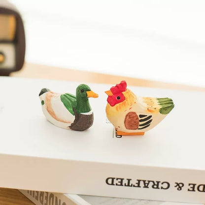 Two carved wooden dog figures sitting on a newspaper with a decorative tree in the background.