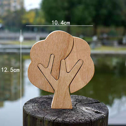 A DIY hand-carved wooden tree, measuring 10.4cm wide and 12.5cm tall, displayed on a rustic log by a serene water body.