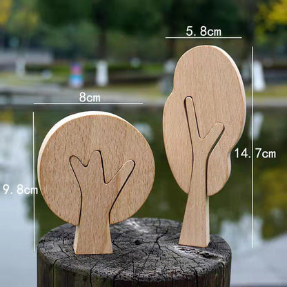 Hand-carved wooden trees displayed on a rustic log with size dimensions provided.