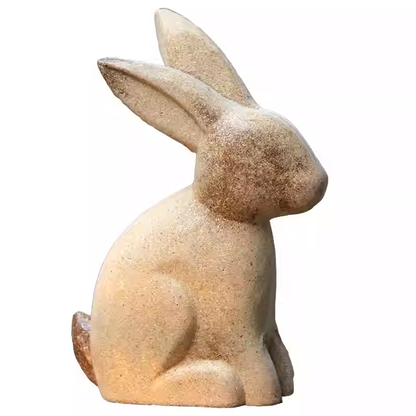 A decorative stone sculpture of a sitting bunny, showcasing its detailed ears and gentle posture.