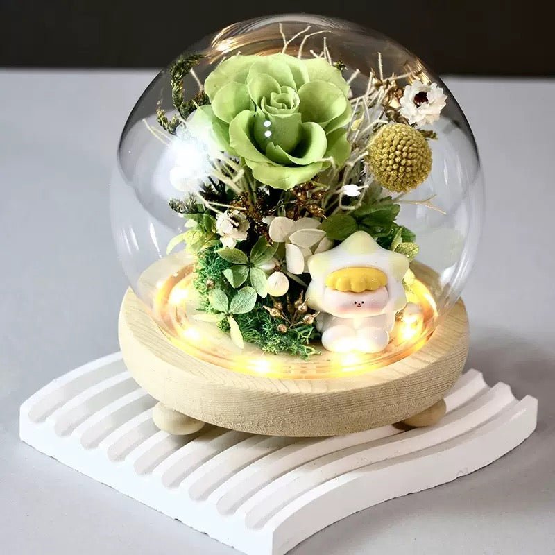 DIY preserved flower arrangement in a glass dome featuring green hydrangeas and rose