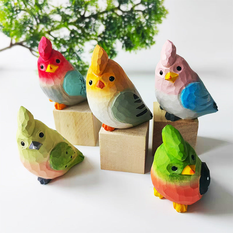 Five hand-carved wooden budgie figurines displayed as a colorful bird collection