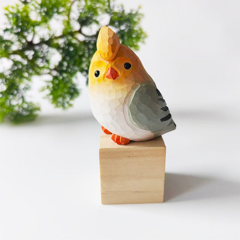 Golden and grey hand-carved wooden budgie figurine on a walnut base