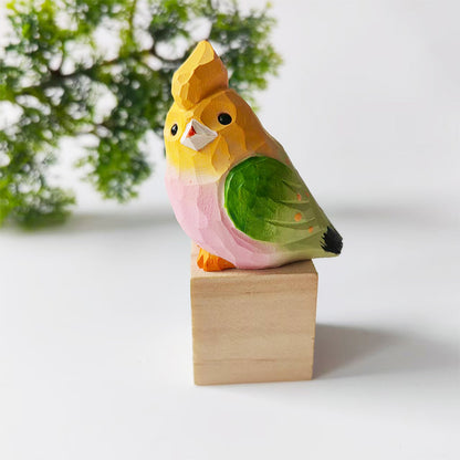 Yellow and green hand-carved wooden budgie figurine on a walnut base