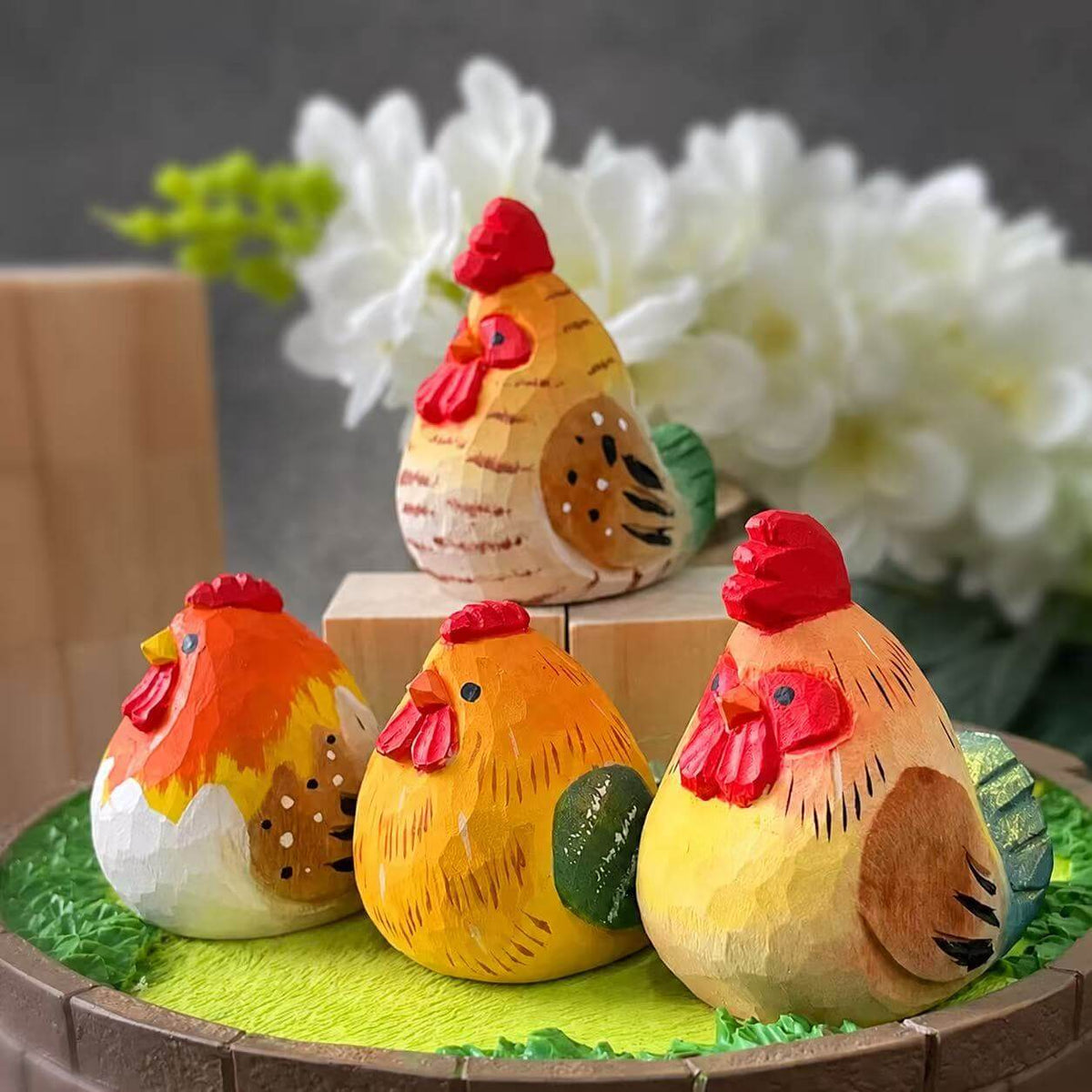 Colorful hand-painted wooden rooster and hen figurines displayed outdoors
