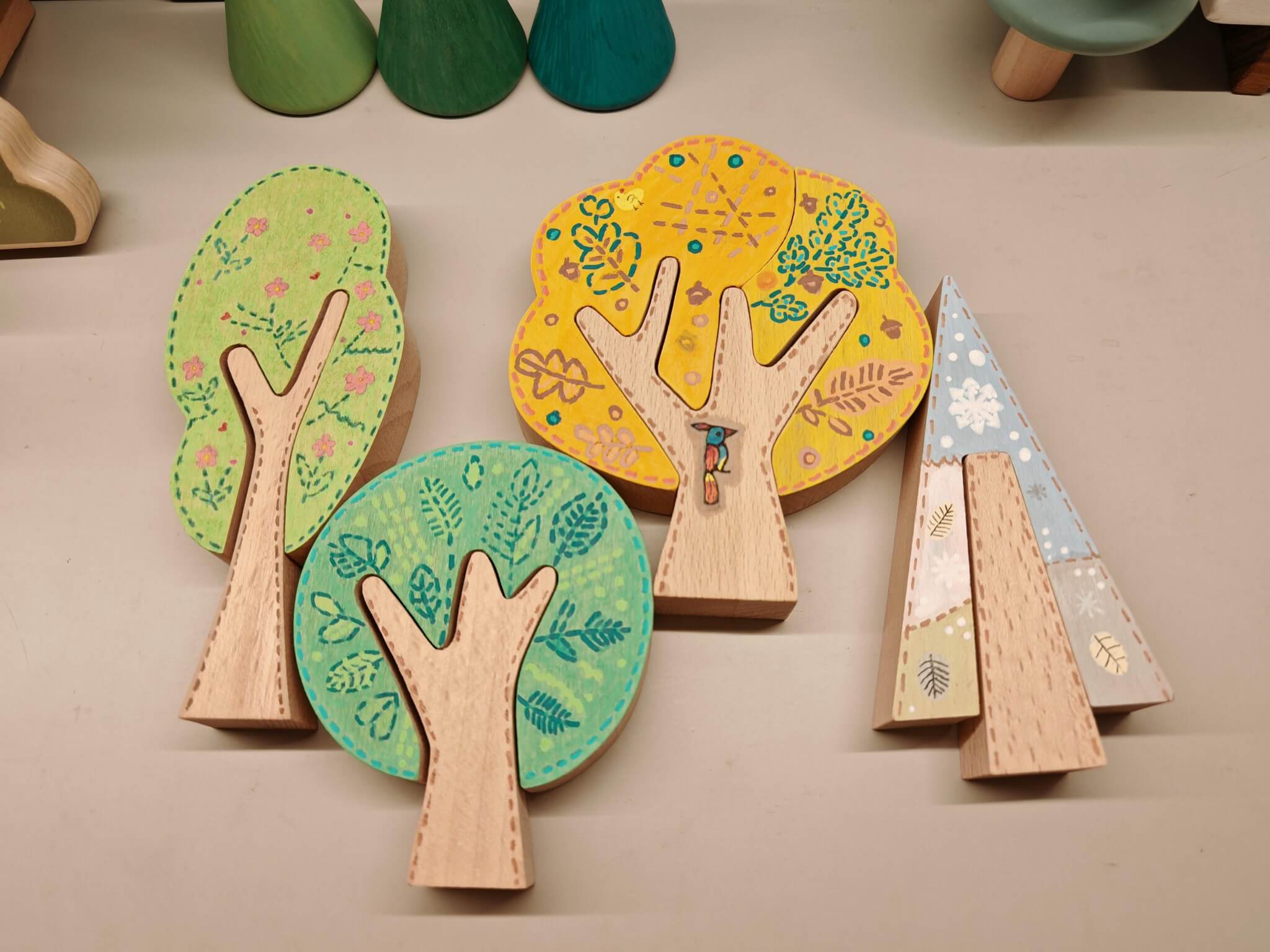 Hand-painted wooden trees arranged together in a flat lay