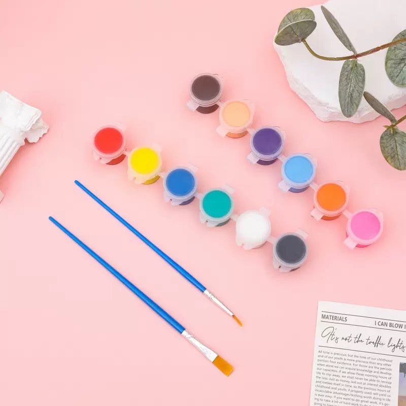 Two strips of colorful mini paint pots paired with fine and flat tip brushes