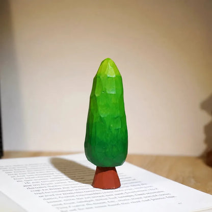 Large green painted wooden tree displayed on an open English book