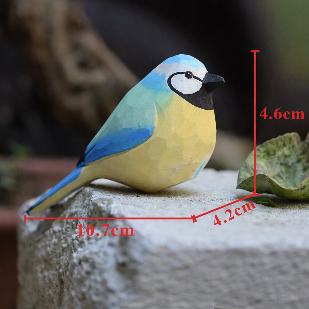 Artisan carved painted robin perched gracefully on a thin branch in a garden