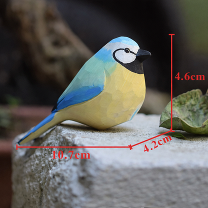Artisan carved painted robin perched gracefully on a thin branch in a garden