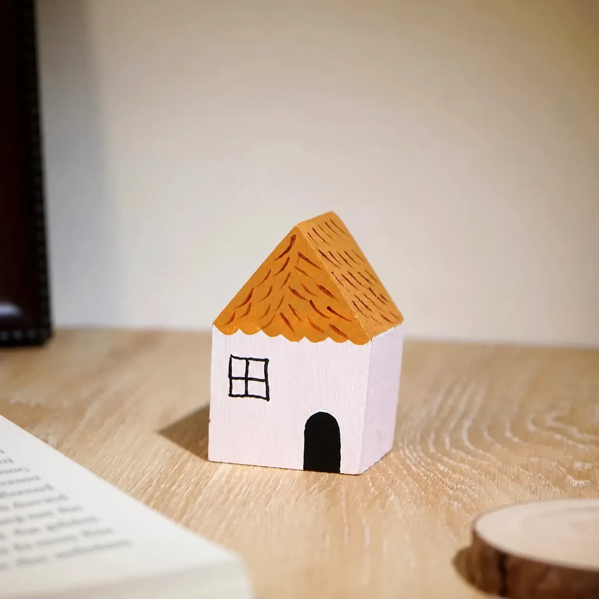 White painted wooden house displayed on a rustic wooden table