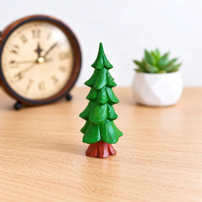 Hand-painted wooden Christmas tree displayed beside a vintage clock and holiday decor