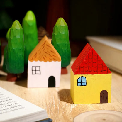 Colorful painted wooden village arranged with green wooden trees
