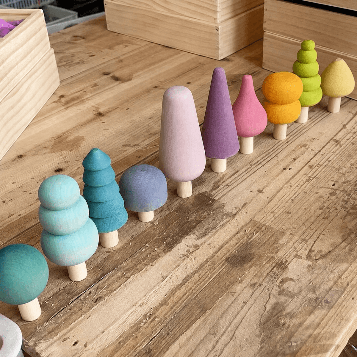 Pastel painted mini wooden trees arranged as a forest display