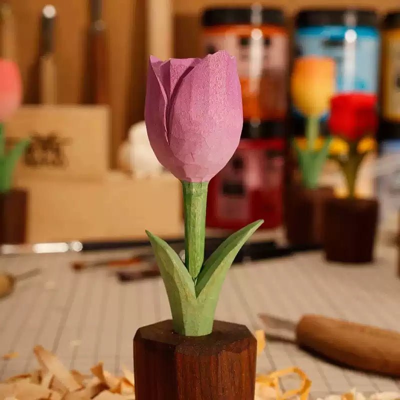 A beautifully crafted wooden tulip with purple petals and green leaves, set against a backdrop of woodworking tools.