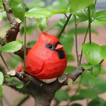 A handcrafted wooden bird sculpture with a vibrant red body, black beak, and expressive black eyes, painted with acrylics and perfect as a unique home decor accent