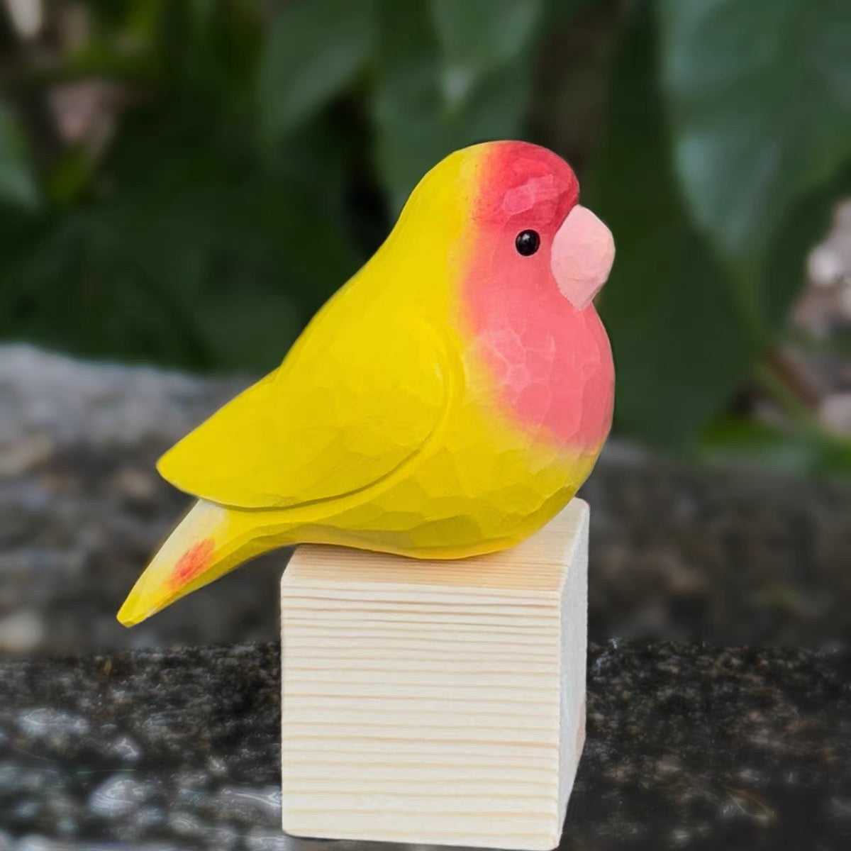 Red and yellow hand-painted wooden parrot side view