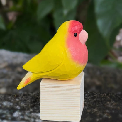 Red and yellow hand-painted wooden parrot side view