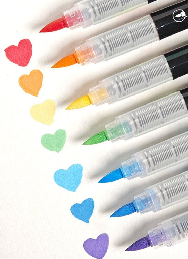 Colorful ink pens lined up above hearts drawn in various colors on paper.