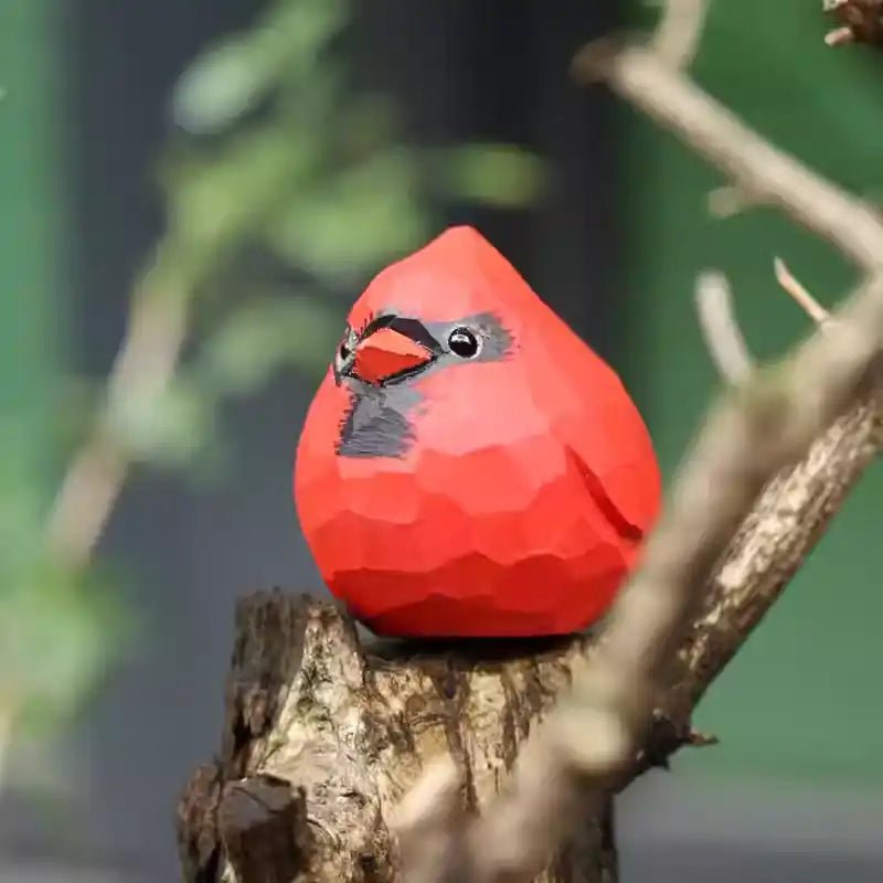 A vibrant red cardinal ornament perched on a branch, showcasing its geometric design.