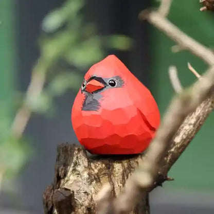 A vibrant red cardinal ornament perched on a branch, showcasing its geometric design.