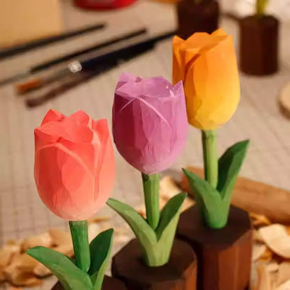 Colorful wooden tulip flowers in handcrafted pots with art supplies in the background.