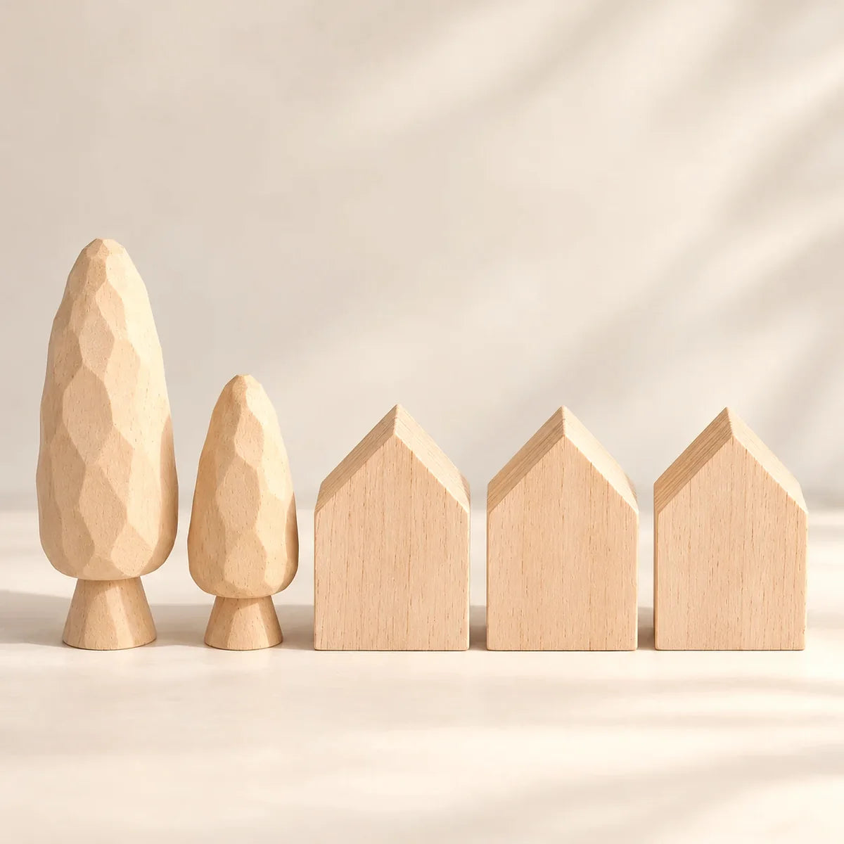 Unfinished wooden houses and trees arranged in a sunlit village display
