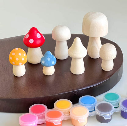 Unfinished and painted wooden mushroom figurines displayed with colorful paints.