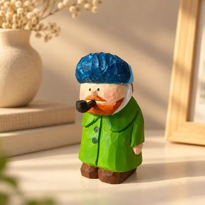Hand-carved Van Gogh wooden figurine wearing a blue cap and green coat while holding a pipe