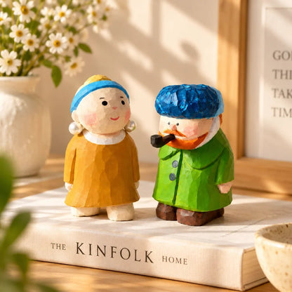Pearl Girl and Van Gogh hand-carved wooden figurines displayed beside books and flowers as home decor
