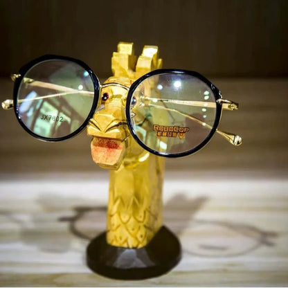Tall wooden giraffe figure designed to hold glasses on a bedside table