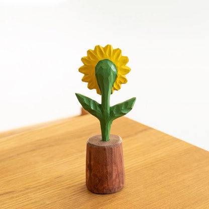 Back view of a hand-carved wooden sunflower figurine in a wooden pot