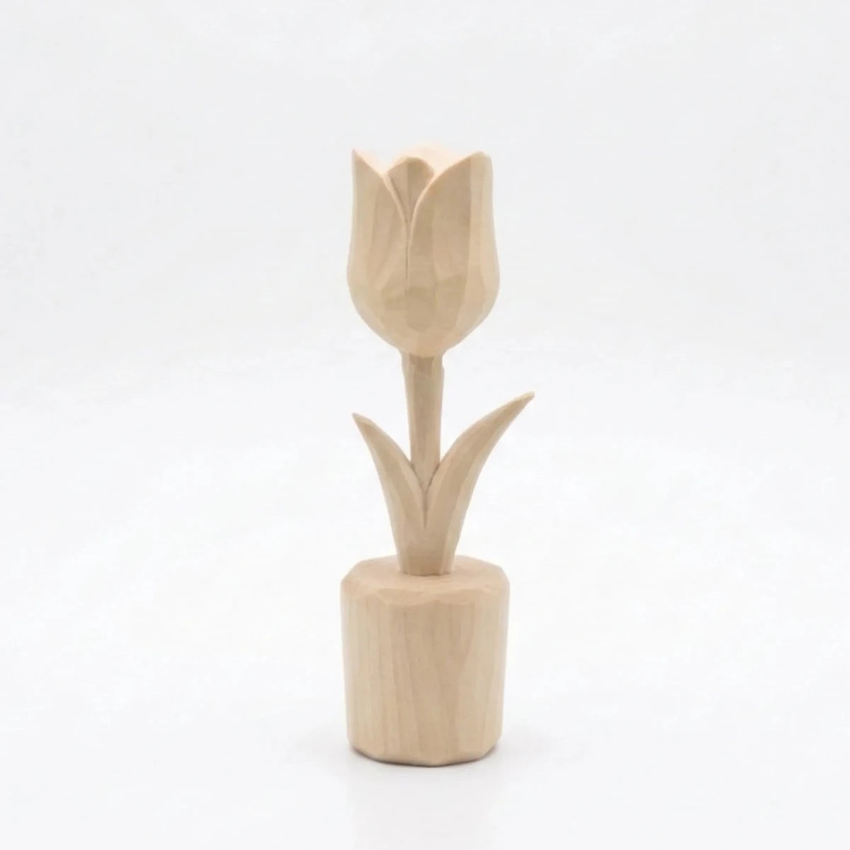 A carved wooden tulip figurine with a smooth finish and detailed petals.