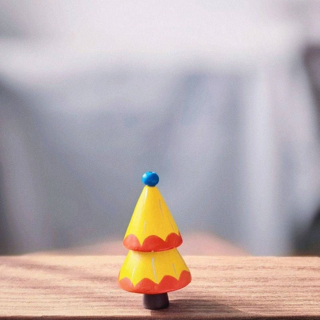 Hand-painted yellow wooden Christmas tree with red scallop details and a blue bead topper.